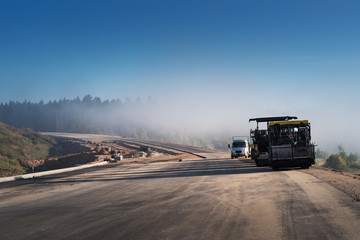 Road construction works with roller compactor machine and asphalt finisher