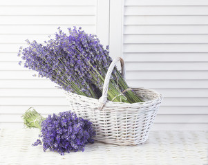 Basket with a lavender over white shutters.