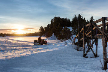 Motoneige sur un lac gelé en Laponie suédoise au lever du soleil