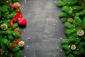 Christmas and New Year background. Christmas tree branch on a black background. Cones and fur-tree toys. View from above.