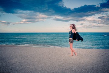 Fototapeta na wymiar Femme sur la plage au coucher du soleil