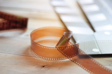 Movie clapper and film strip on a wooden background