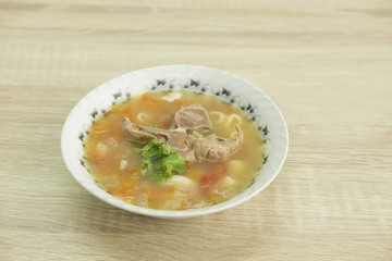BONE BROTH TOMATO SOUP WITH MACARONI
Bone broth tomato soup with  macaroni in a white bowl decorated with green coriander. 
