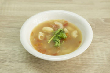 BONE BROTH TOMATO SOUP WITH MACARONI
Bone broth tomato soup with  macaroni in a white bowl decorated with green coriander. 