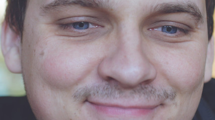 Portrait of young handsome smiling man with beautiful blue eyes