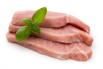 Fresh pork fillet with basil on a white background.