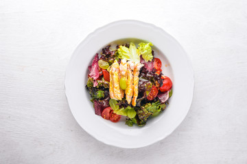 Vegetable salad with chicken and mango sauce on a wooden background. Top view. Free space for text.