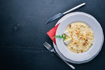 Risotto with cheese on a wooden background. Top view. Free space for text.