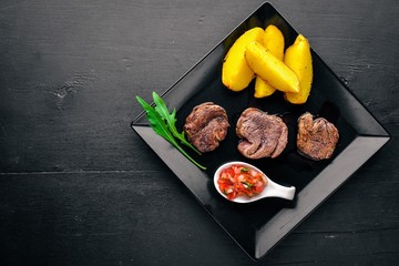 Veal medallions on a wooden background. Top view. Free space for text.