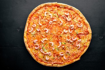Pizza with shrimp. On a wooden background. Top view. Free space for text.
