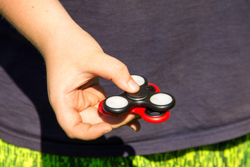 Boy playing with two fidget spinner stress relieving toys outdoor