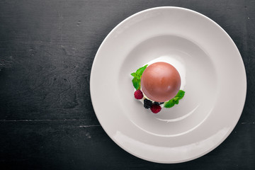 Ice-cream with wild berries and chocolate. On a wooden background. Top view. Free space for text.