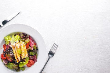 Vegetable salad with chicken and mango sauce on a wooden background. Top view. Free space for text.