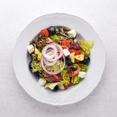 Greek salad. Fresh vegetables on a wooden background. Top view. Free space for text.