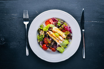 Vegetable salad with chicken and mango sauce on a wooden background. Top view. Free space for text.