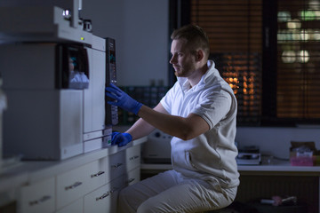 Portrait of a male researcher carrying out scientific research in a lab (shallow DOF; color toned...