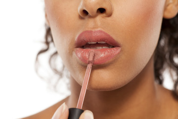 Naklejka premium young beautiful black woman applied lipstick