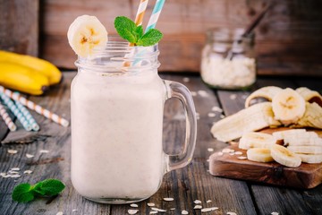 banana smoothie with oatmeal in mason jar on a wooden background