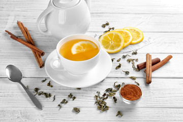 Beautiful composition with cup of cinnamon tea on wooden table