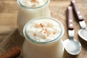 Creamy rice pudding with cinnamon powder on table, closeup