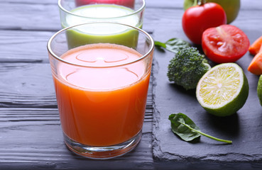 Fresh juices in glasses with ingredients on wooden table
