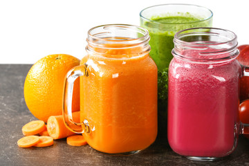 Mason jars with fresh juices and ingredients on table