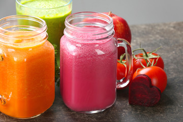 Mason jars with fresh juices and ingredients on table