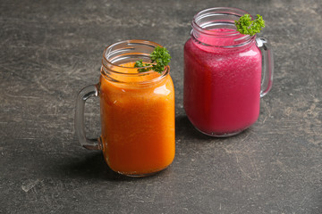 Mason jars with fresh vegetable juices on table