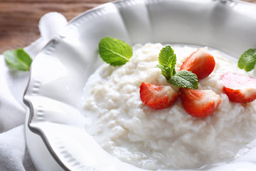 Creamy rice pudding with strawberry in plate, closeup