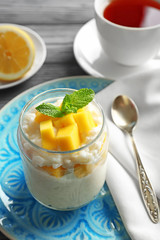 Creamy rice pudding with fruit in jar on table