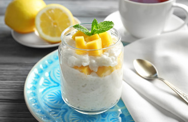 Creamy rice pudding with fruit in jar on table