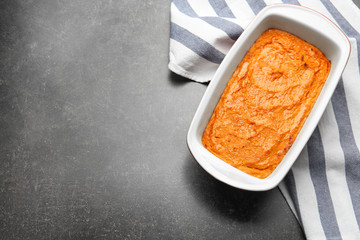 Baking dish with tasty carrot souffle on table