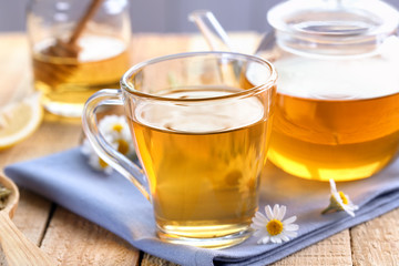 Cup and teapot of chamomile tea on table