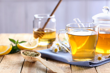 Cup and teapot of chamomile tea on table