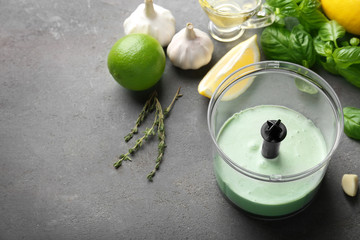 Tasty creamy lime sauce for fish taco in blender bowl on kitchen table