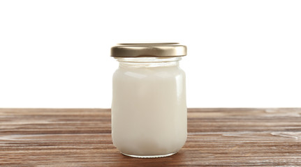 Coconut oil in mason jar on table against white background