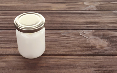 Coconut oil in jar on wooden background