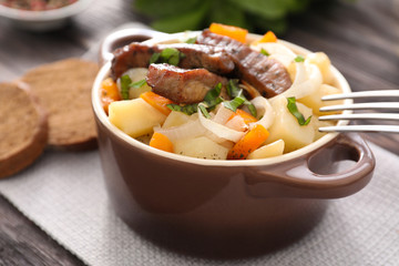 Casserole with tasty meat and potatoes on table