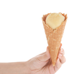 Woman holding waffle cone with delicious vanilla ice-cream on white background