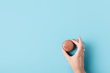 female hand holding macaron