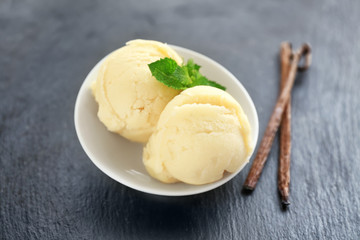 Bowl with delicious vanilla ice-cream balls on table