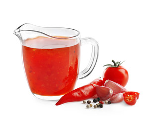 Composition with chili sauce in jug, isolated on white