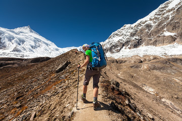 Hiker is climbig to Manaslu base camp in highlands of Himalayas on Manaslu circuit