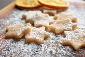 Raw cookies sprinkled with flour on wooden board