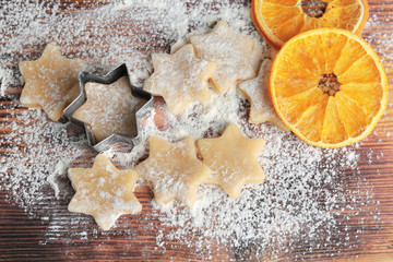 Composition of raw cookies and dried orange on wooden board