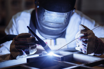Industrial Worker at the factory welding closeup