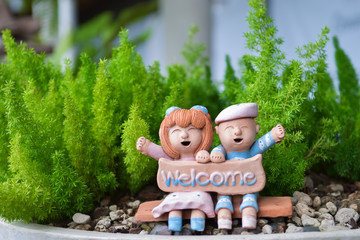 Smiling and laughing boy and girl clay doll with welcome word in the garden, Happiness concept. - 171167409