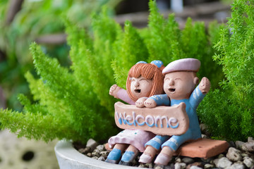 Smiling and laughing boy and girl clay doll with welcome word in the garden, Happiness concept. - 171167438