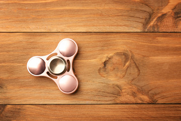 Modern spinner on wooden background