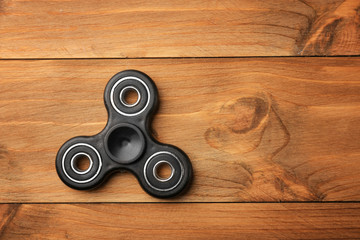 Modern spinner on wooden background